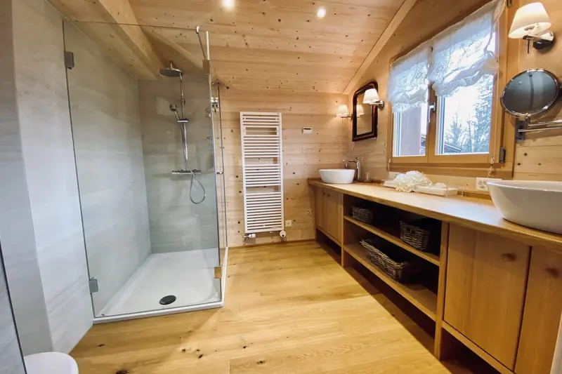 Bathroom with a shower and two basins on a wooden vanity