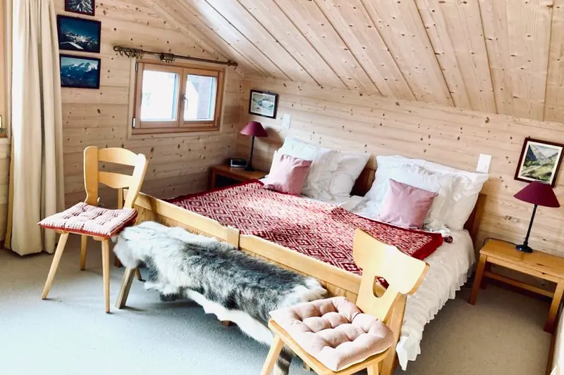 Bedroom under the roof, with a double bed and a sheepskin