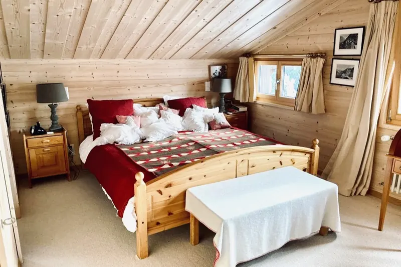 Bedroom with a wooden double bed and a red throw