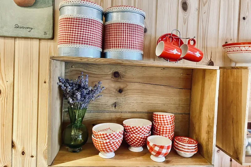 Red and white bowls and mugs on a wooden shelf
