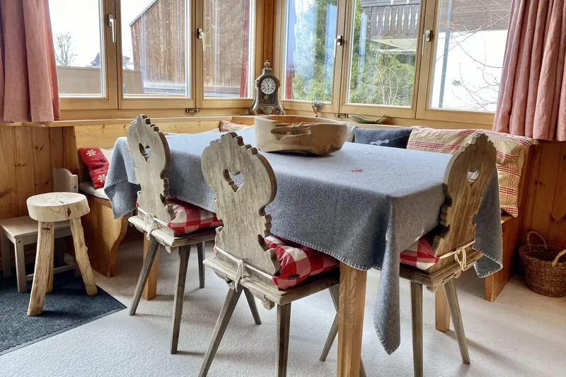 The dining table, a heart cut into every chair back
