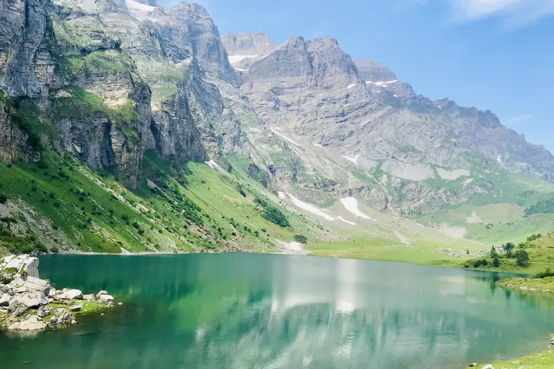 A turquoise mountain lake below high rock walls