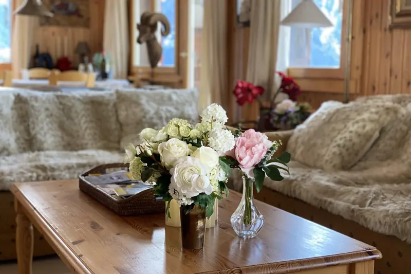 Sofas with fur throws, flowers on the coffee table
